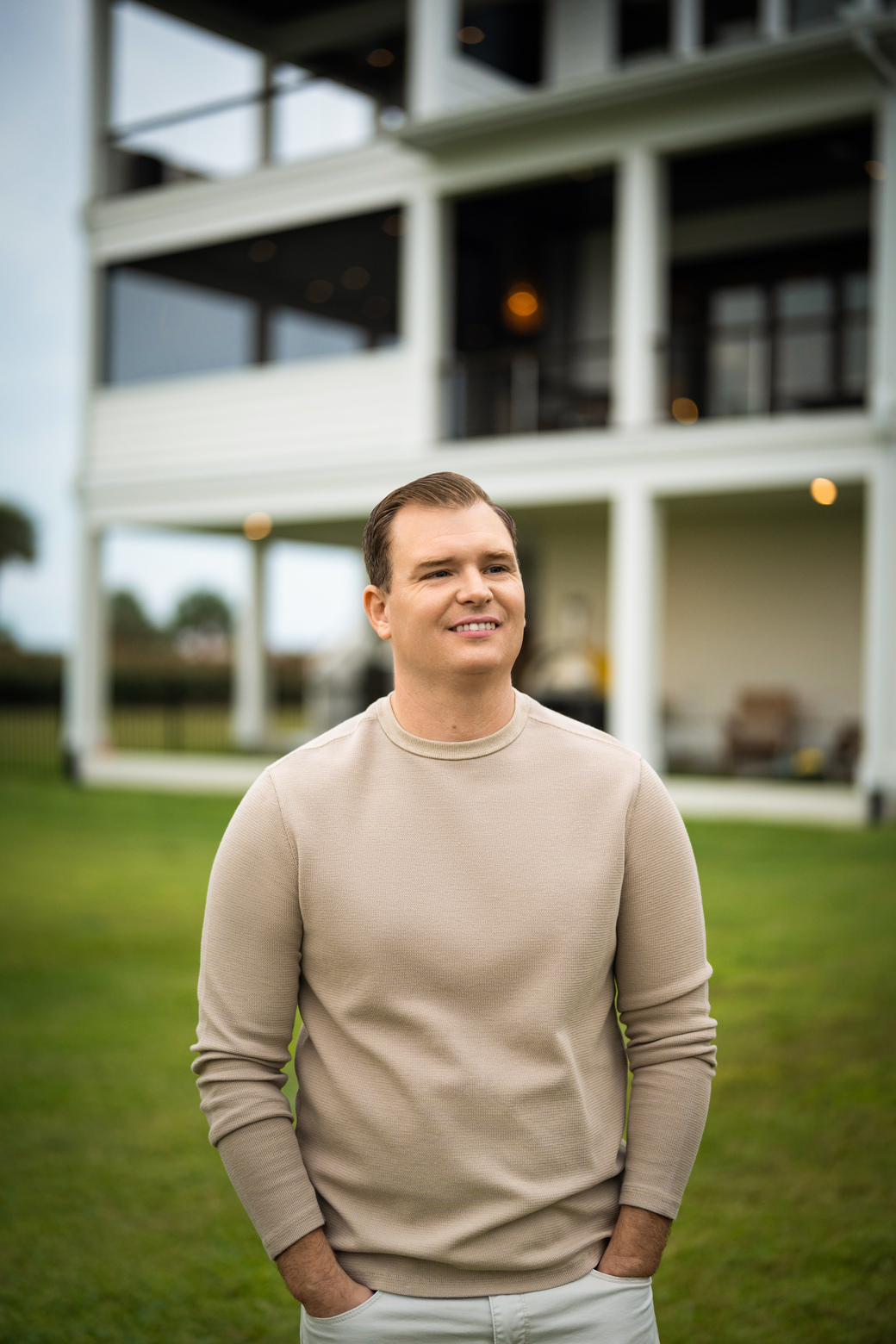 Alex McKinney standing outside a coastal home